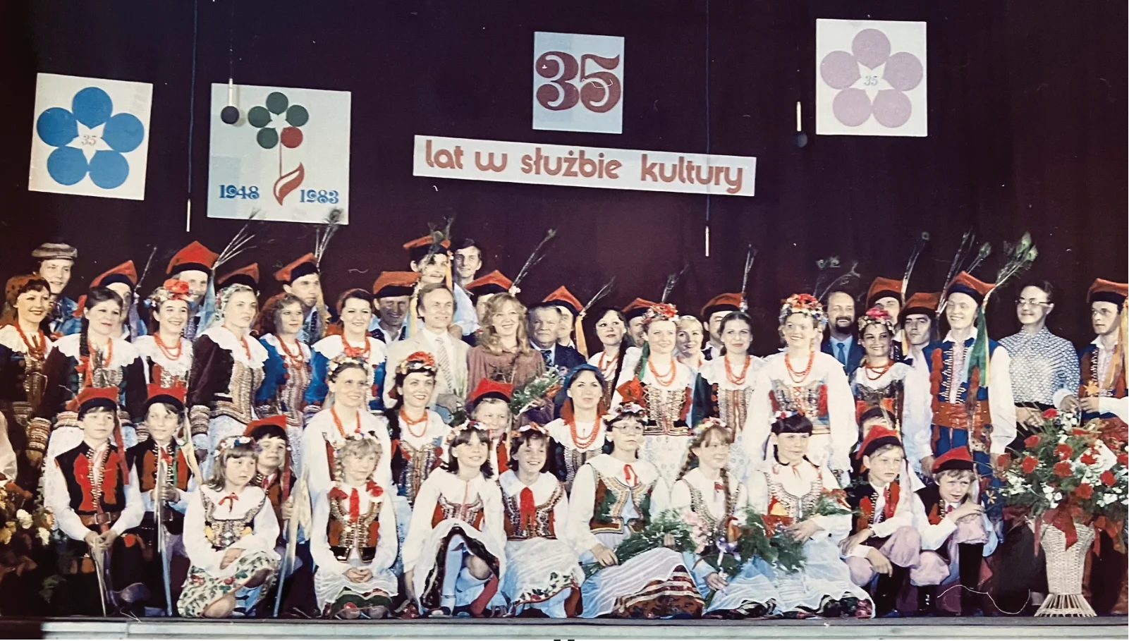 Wspólny portret członków zespołu na scenie pod napisem 35 lat w służbie kultury